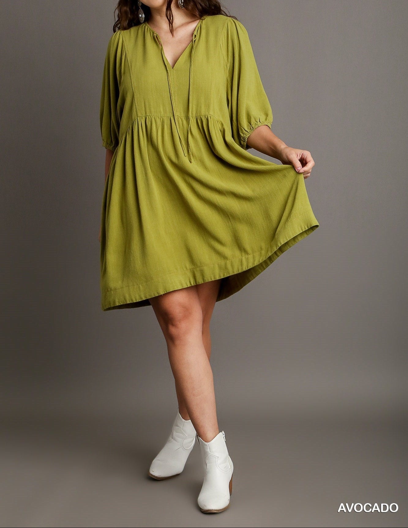 Woman wearing a green dress with a plain background