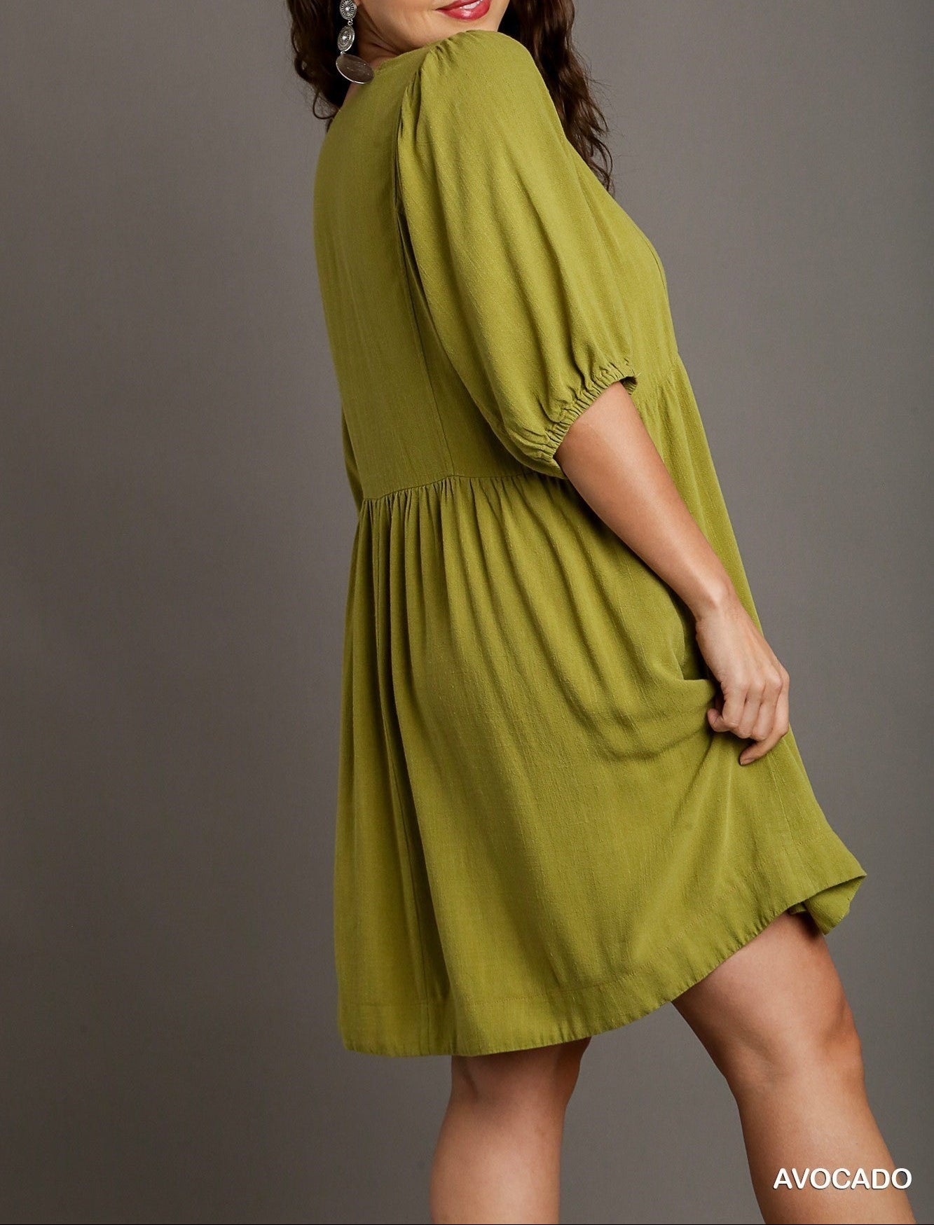 Woman wearing a green dress with 'Plus Size' and 'Avocado' text on a gray background