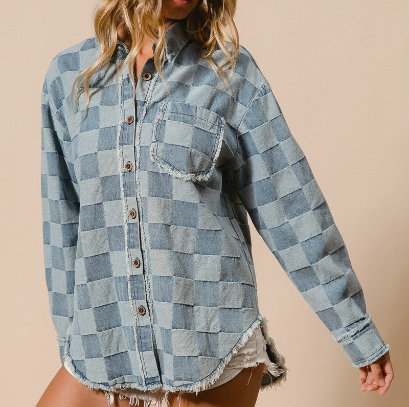 Woman wearing a checkered denim shirt and hat on a beige background