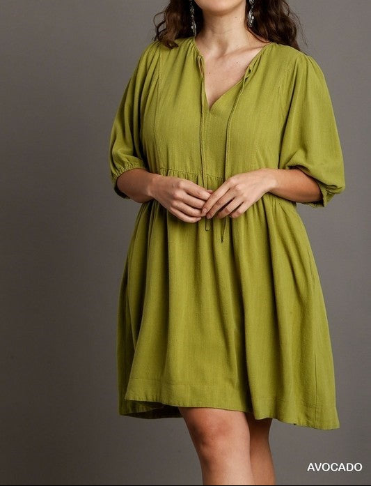 Woman wearing a green dress against a gray background