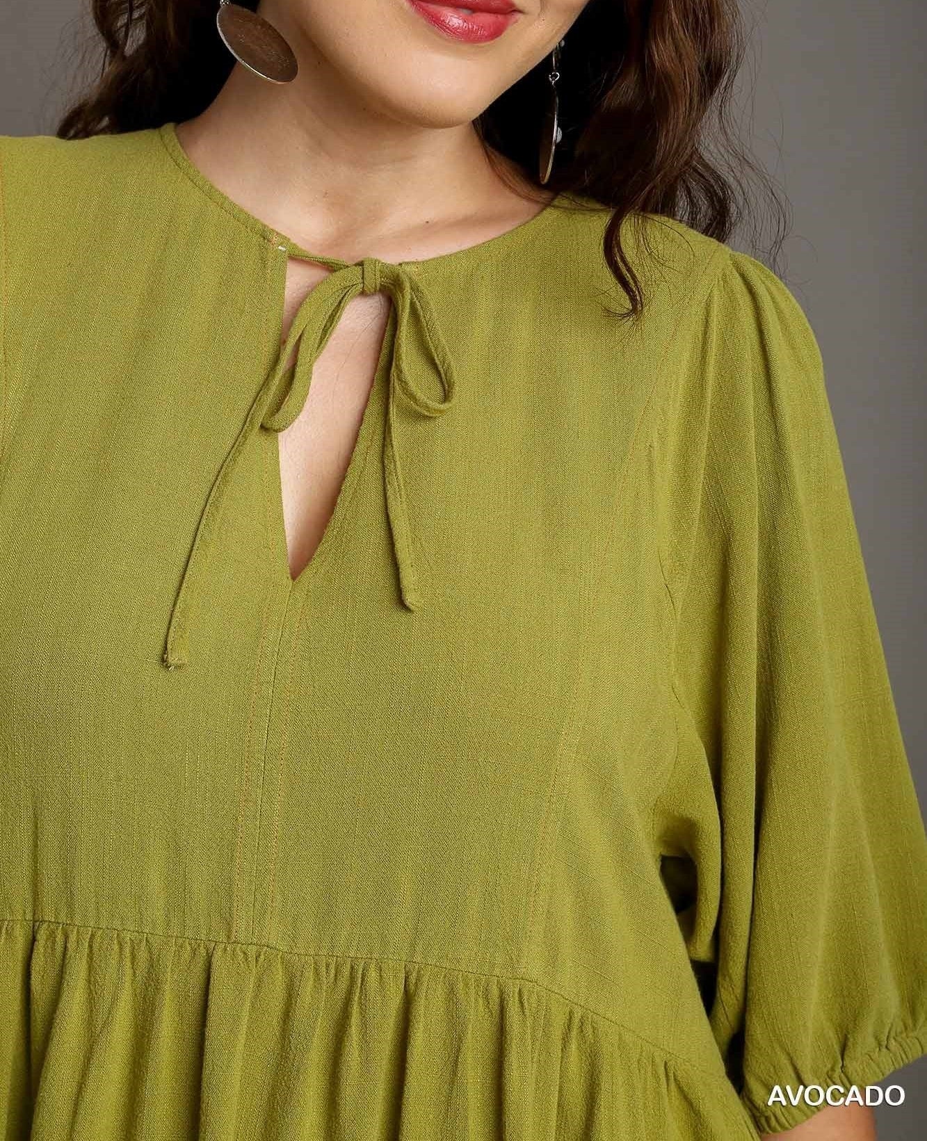 Woman wearing a green dress with a plain background
