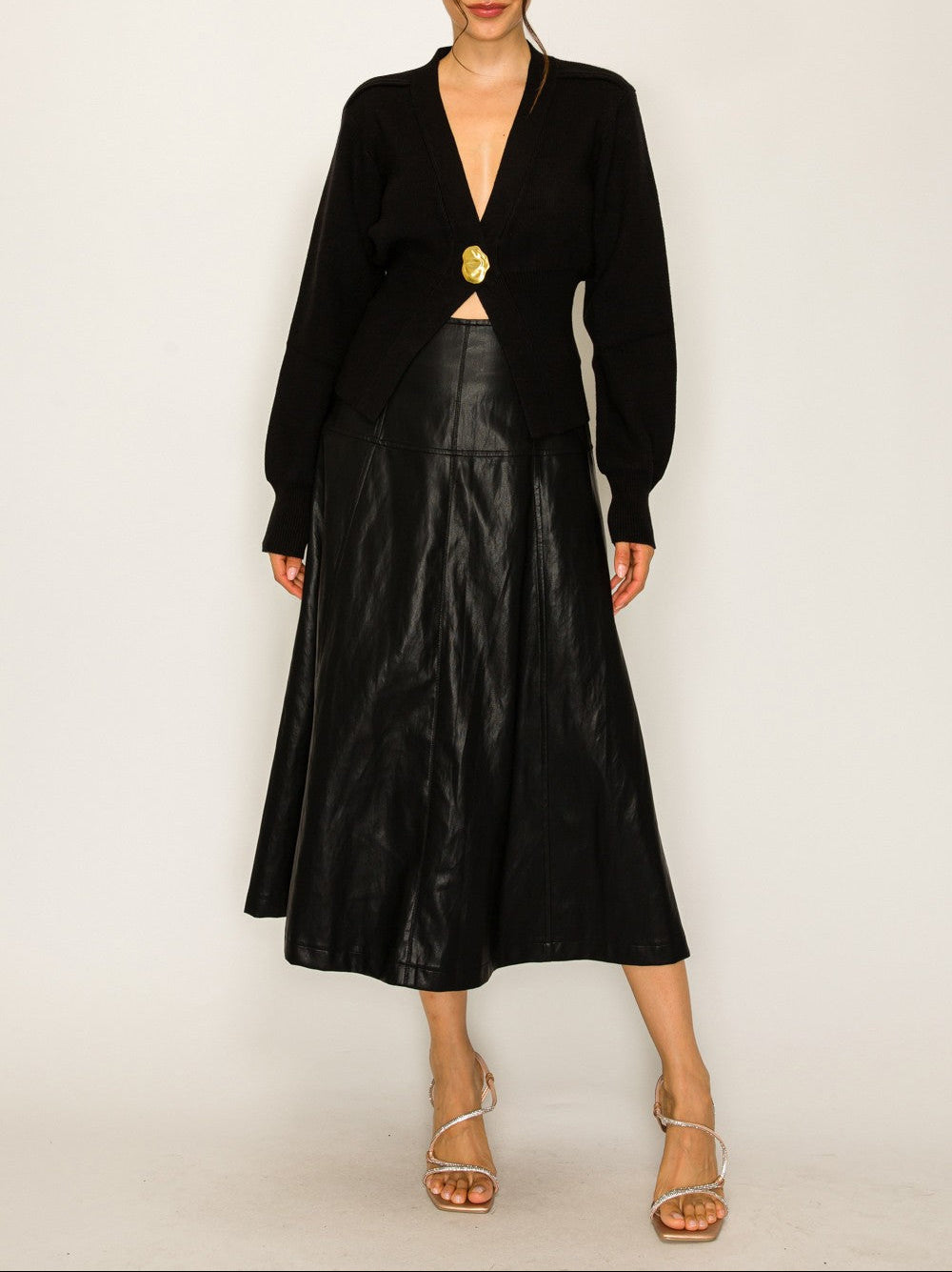 Woman wearing a black blazer and leather skirt on a white background