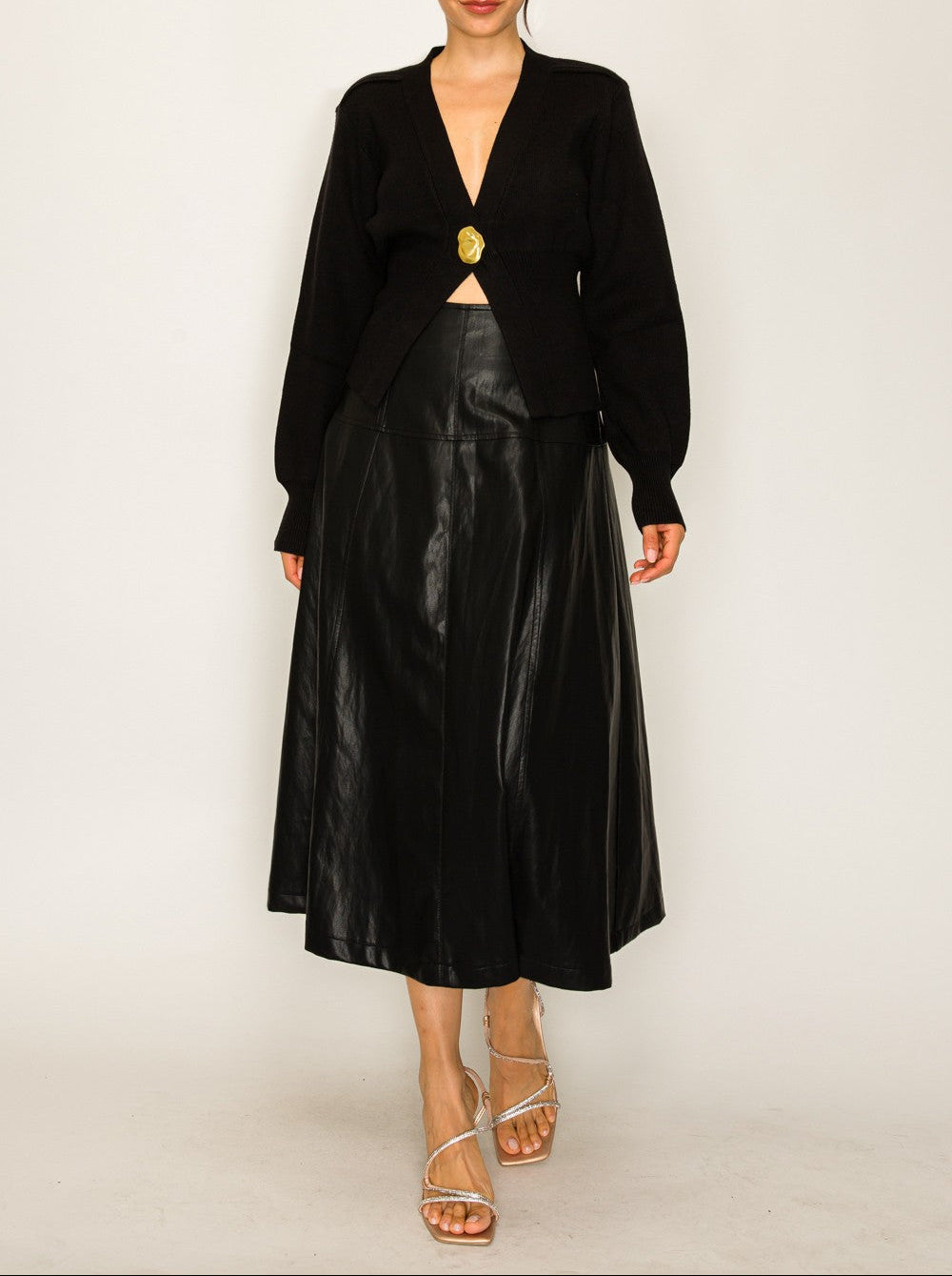Woman wearing a black blazer and leather skirt on a white background