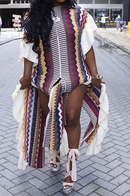 Woman wearing a colorful patterned dress with a slit on a city street.