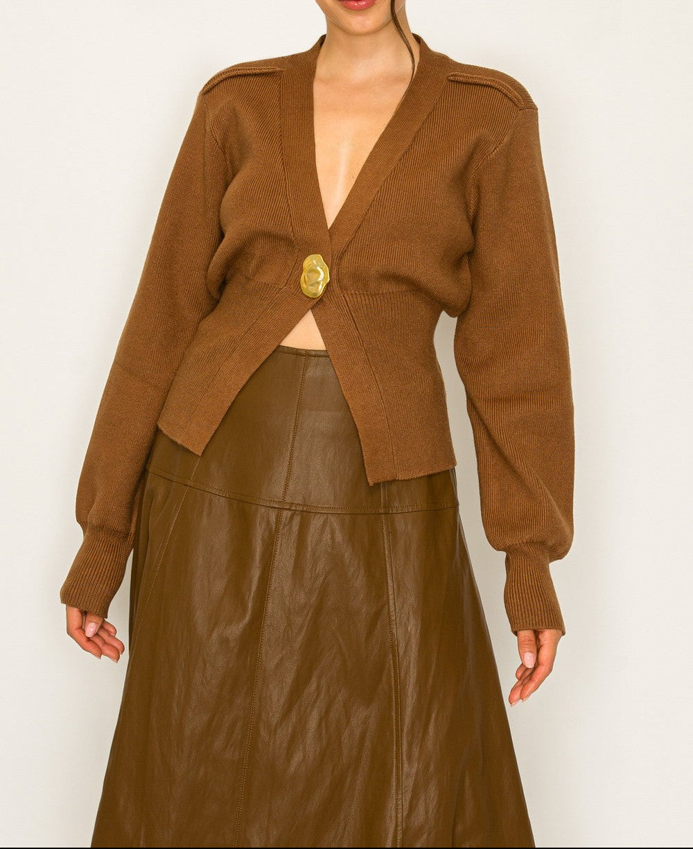 Woman wearing a brown jacket and leather skirt against a white background