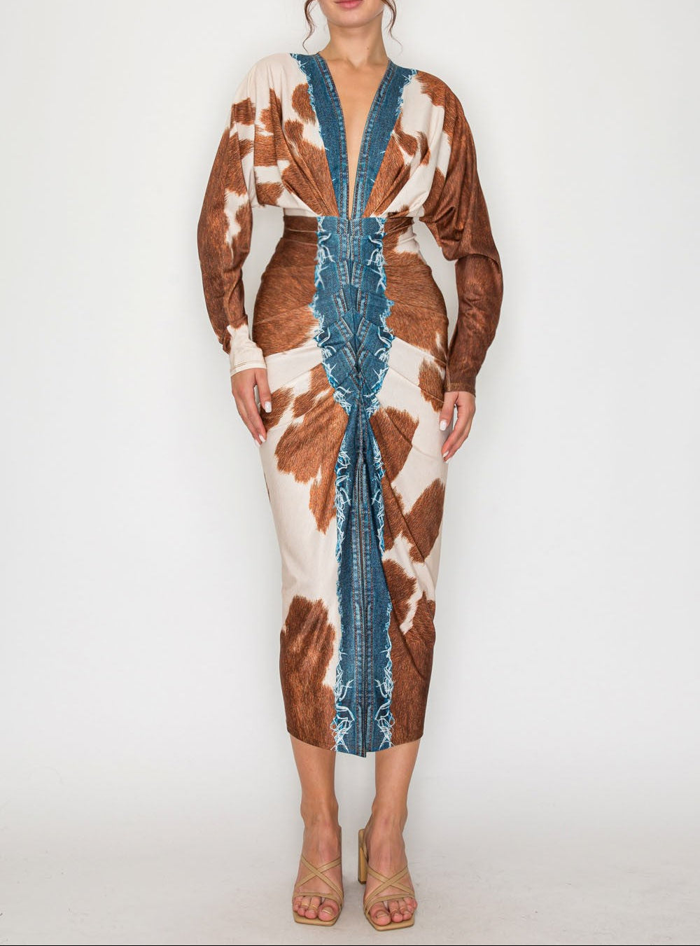 Woman wearing a cow print dress with blue accents on a white background