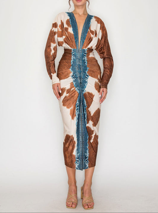 Woman wearing a cow print dress with blue accents on a white background
