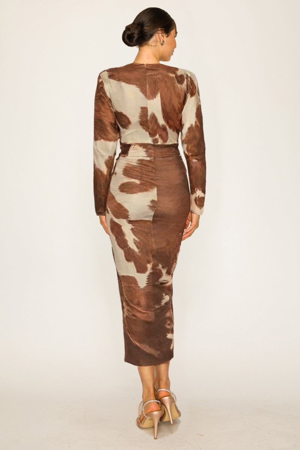 Woman wearing a brown and beige patterned dress on a white background