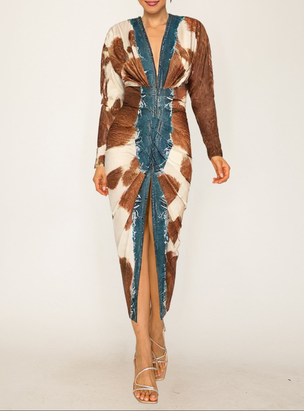 Woman wearing a long, patterned dress with a high slit on a white background