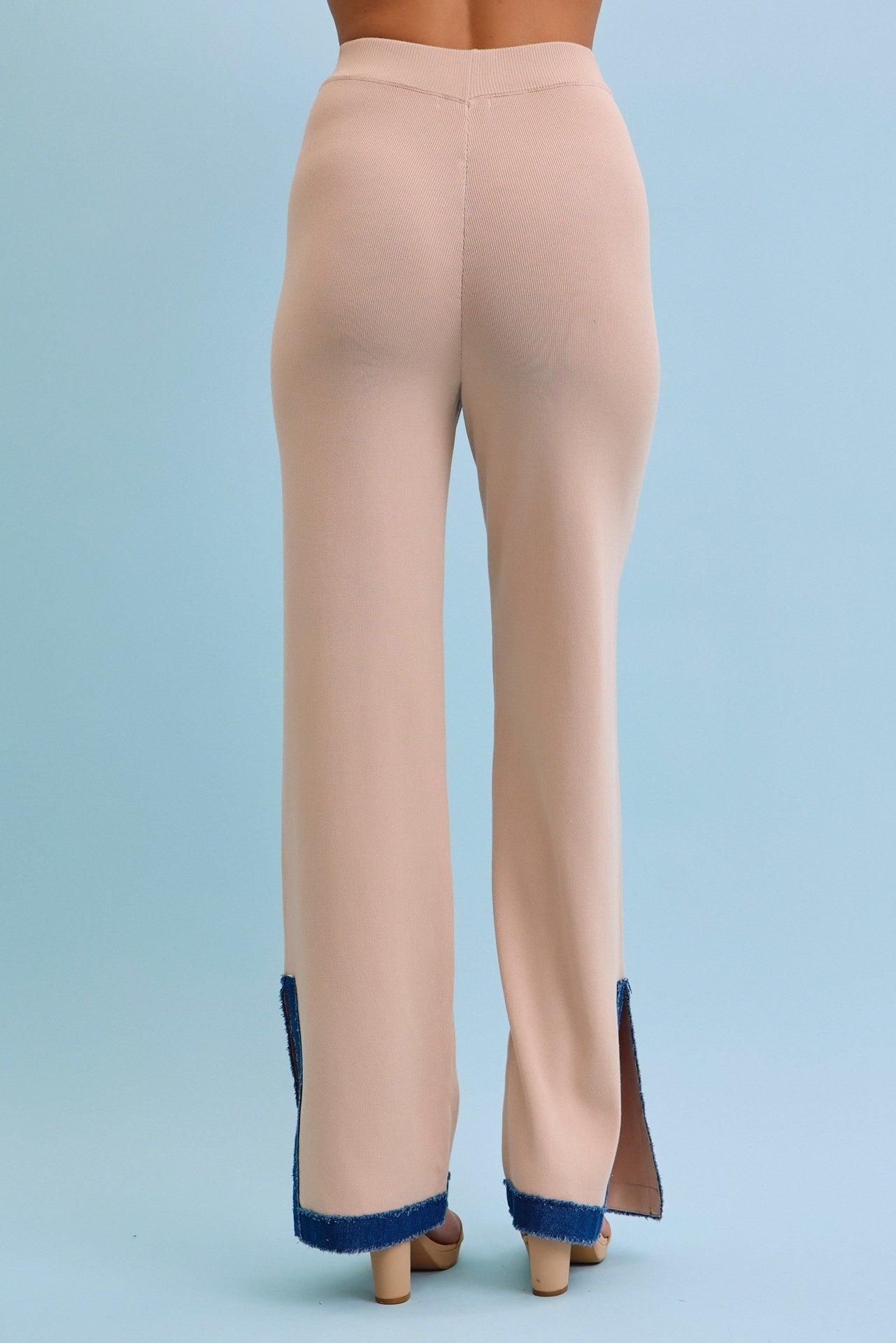 Beige pants with blue trim on a light blue background