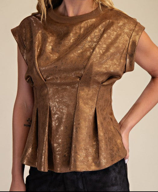 Woman wearing a bronze metallic top against a beige background