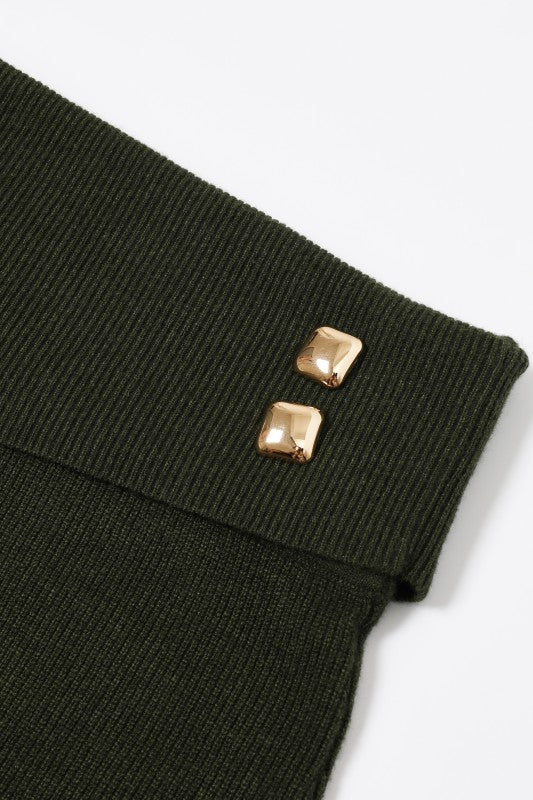 Close-up of a black ribbed garment with gold buttons on a white background