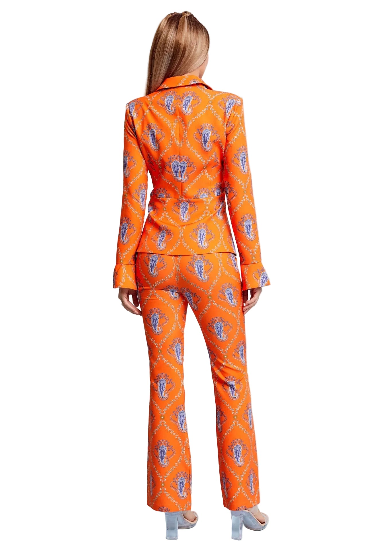 Woman wearing an orange patterned suit on a light blue background